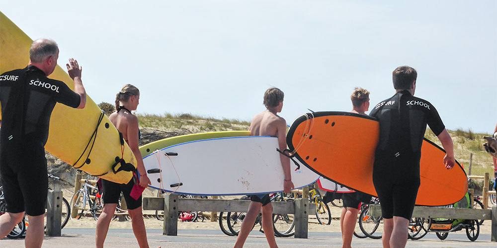 Surfschool onderweg naar de surfles Watersport, surfen en stranden